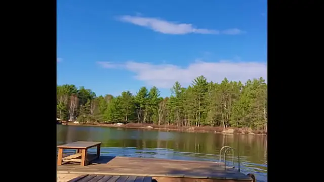 Petite Blonde jumps off a dock into a lake completely naked